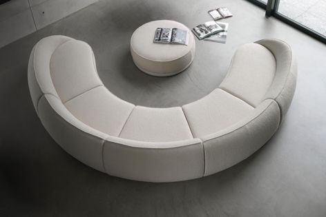 Designed by Lorenza Bozzoli, the Abbracci modular sofa by Ghidini1961 has generous proportions and a sculptural form. A rounded backrest wraps around the full length of the sofa, and a brass ring accents the sofa’s base.